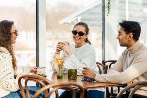 Tre unge på cafe med solbriller på